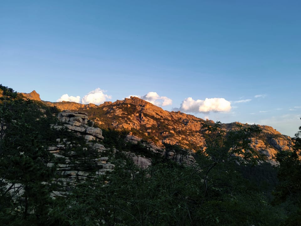夕照下嶙峋的花岗岩山脊与林木