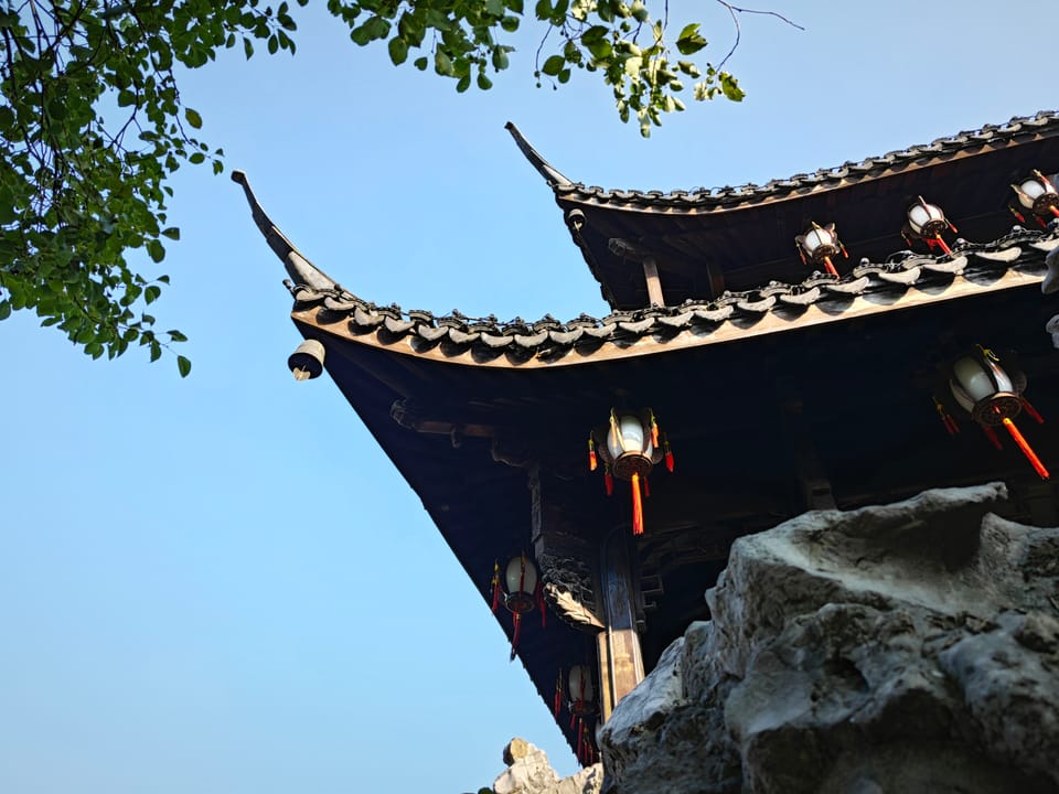 蓝天下翘起的古建飞檐与悬挂的灯笼